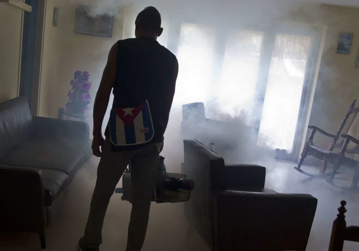 In this Aug. 26, 2016 photo, a government fumigator sprays a home for mosquitos in Havana, Cuba. (AP Photo/Ramon Espinosa)