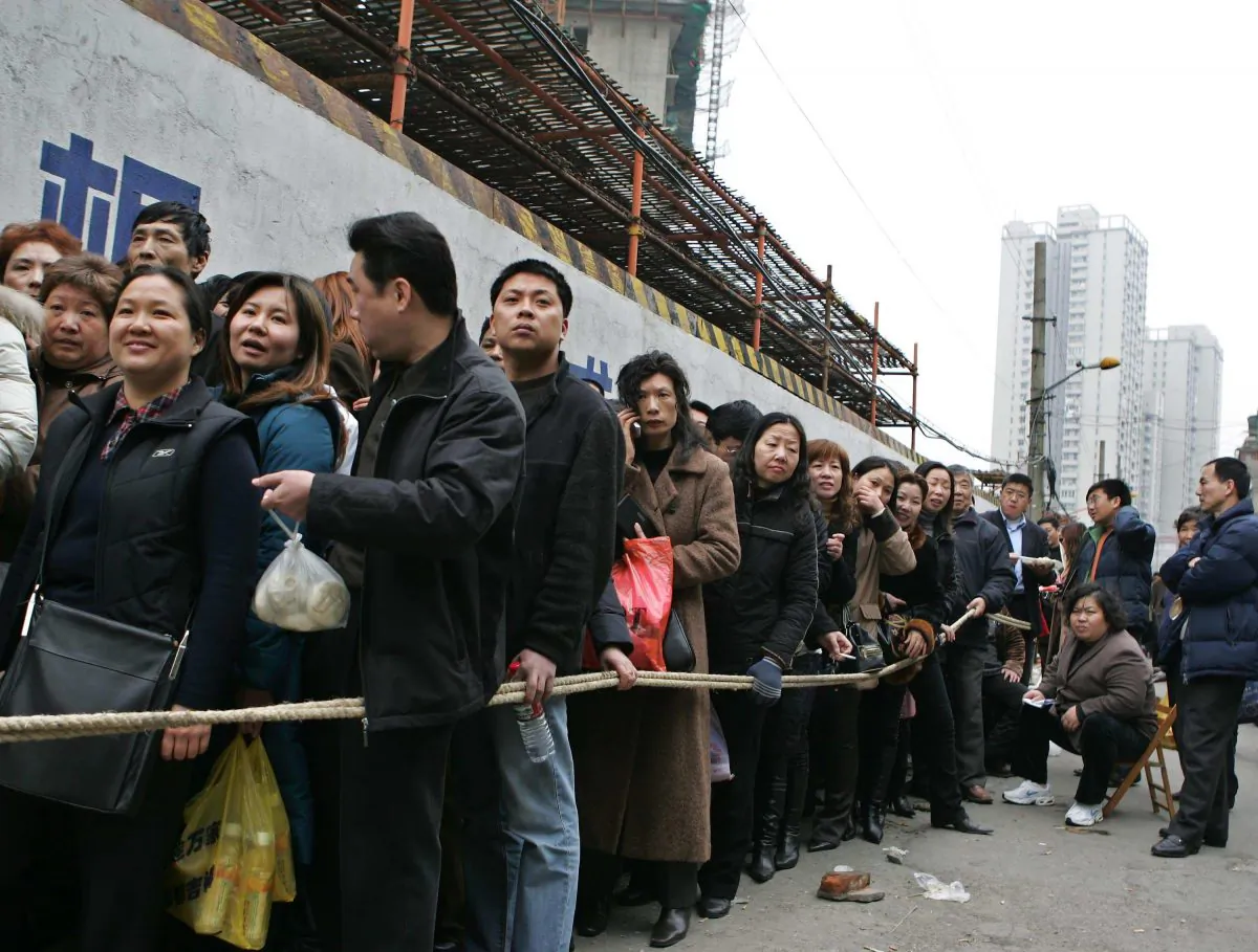 Chinese people form lines outside of a construction site waiting to buy quality apartments in Shanghai, China, on March 2, 2005. (China Photos/Getty Images)