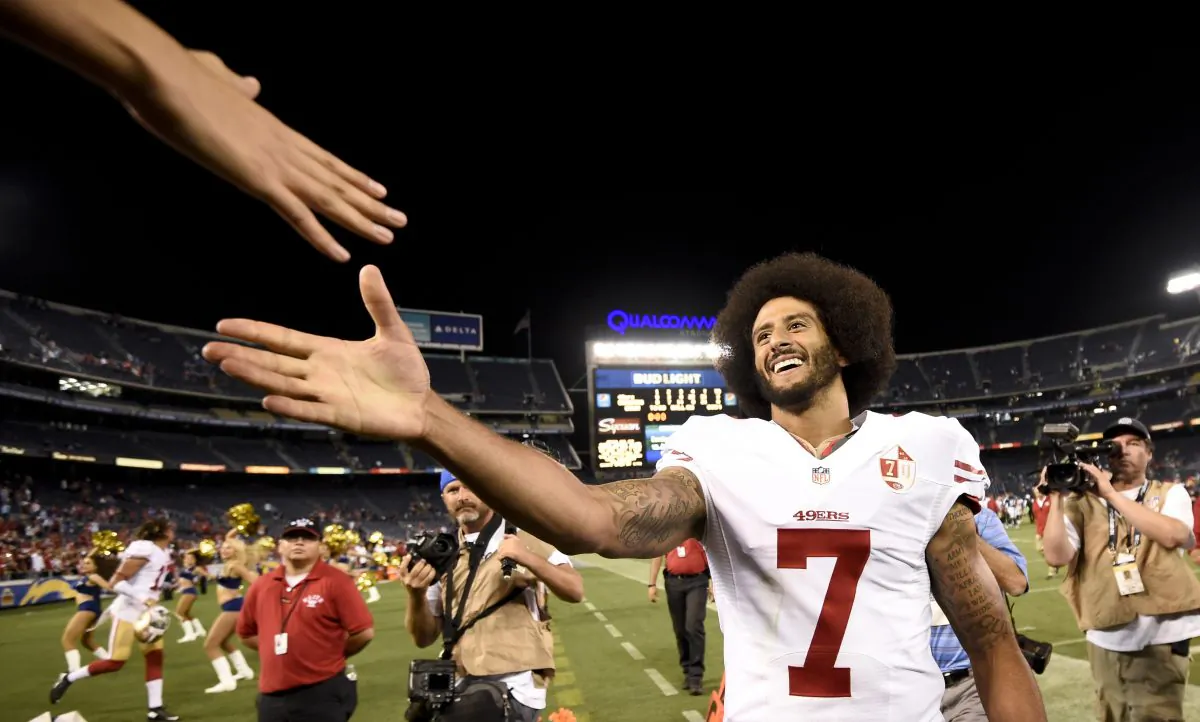 San Francisco 49ers quarterback Colin Kaepernick shakes hands with fans after the 49ers defeated the San Diego Chargers 31-21 during an NFL preseason football game in San Diego on Sept. 1, 2016. Kaepernick's jersey is the league's top seller. (AP Photo/Denis Poroy)