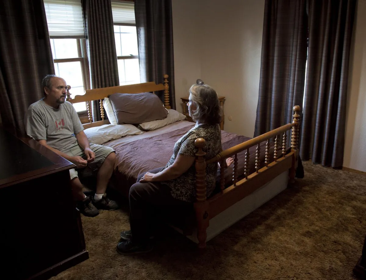 On Aug. 23, 2016, sitting in their son Nigel's bedroom, Mark Youngberg and his wife Sharon recount the events in their Emmett, Idaho home that lead to the 30-year-old's death last spring. The room has gone unchanged since April when Nigel's bouts with schizophrenia and paranoia became critical and he jumped out of a second story window wearing only a robe, light jacket and sneakers. He was confronted by Gem County sheriff's deputies but fled farther into the mountains in the dark of night. His body was found 11 miles away near Montour 16 days later. (Darin Oswald/Idaho Statesman via AP)