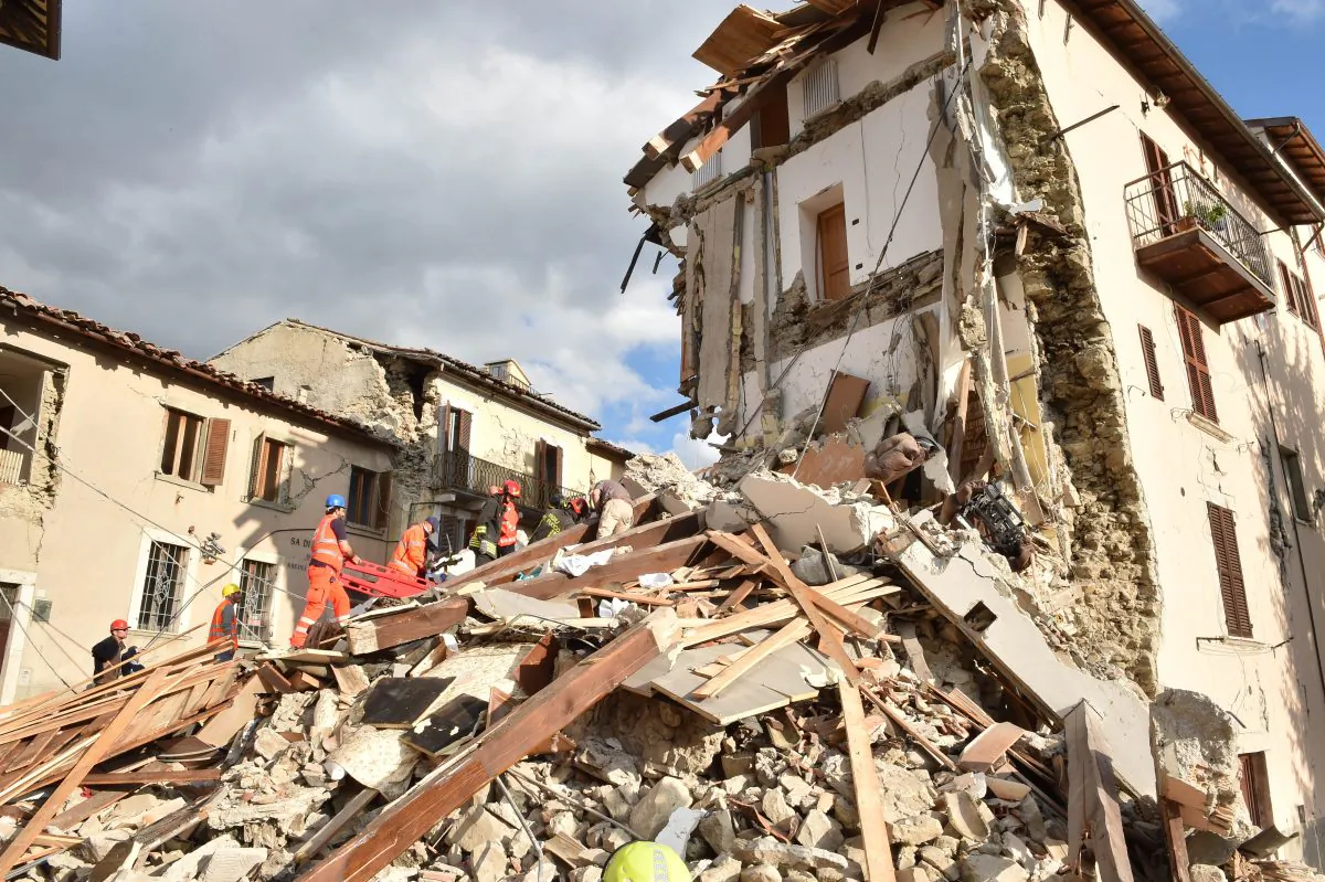 Rescuers clear debris while searching for victims in damaged buildings in Arquata del Tronto, Italy, on Aug. 24, 2016. (Giuseppe Bellini/Getty Images)