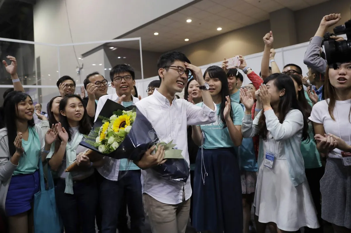 Political party Demosisto's Nathan Law, center, who helped lead the 2014 protests, celebrates with his supporters after winning a seat at the legislative council elections in Hong Kong, Monday, Sept. 5, 2016. A new wave of anti-China activists appeared headed for victory in Hong Kong's most pivotal elections since the handover from Britain in 1997, which could set the stage for a fresh round of political confrontations over Beijing's control of the city. (AP Photo/Kin Cheung)