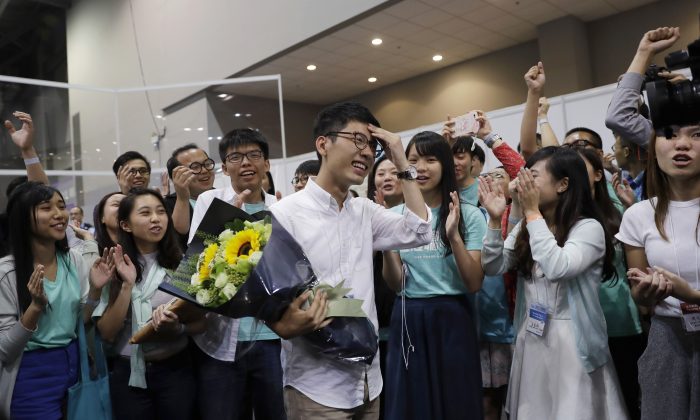 Political party Demosisto's Nathan Law, center, who helped lead the 2014 protests, celebrates with his supporters after winning a seat at the legislative council elections in Hong Kong, Monday, Sept. 5, 2016. A new wave of anti-China activists appeared headed for victory in Hong Kong's most pivotal elections since the handover from Britain in 1997, which could set the stage for a fresh round of political confrontations over Beijing's control of the city. (AP Photo/Kin Cheung)