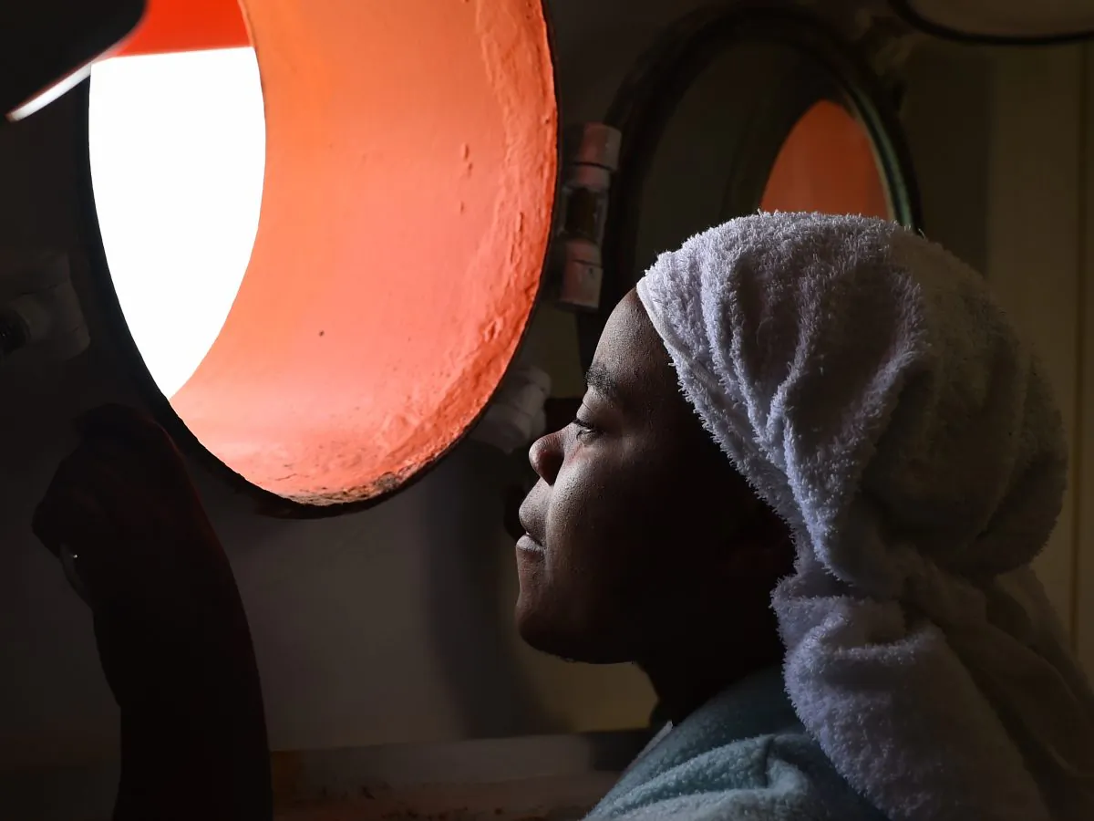 A woman looks through a window of rescue ship "Aquarius" as more the 380 migrants arrive in the port of Cagliari, Sardinia, on May 26, 2016, two days after being rescued near the Libyan coasts. The Aquarius is a former North Atlantic fisheries protection ship now used by humanitarians SOS Mediterranee and Medecins Sans Frontieres (Doctors Without Borders) which patrols to rescue migrants and refugees trying to reach Europe crossing the Mediterranean sea aboard rubber boats or old fishing boat. (Gabriel Bouys/AFP/Getty Images)