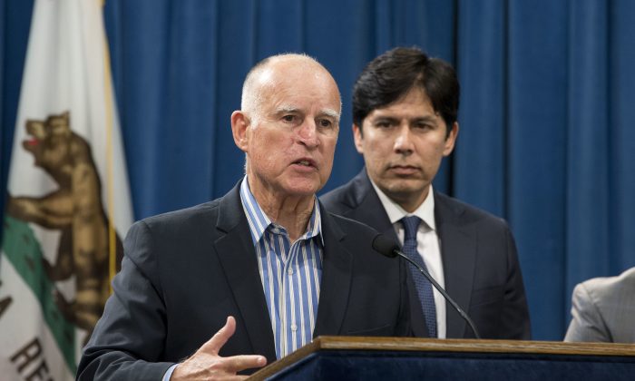 FILE - In this Wednesday, Aug. 24, 2016 file photo, Calif., Gov. Jerry Brown announced that he would sign a pair of environmental bills approved by the Legislature, during a news conference in Sacramento, Calif. At right, is Senate President Pro Tem Kevin de Leon, D-Los Angeles. Brown is set to extend the nation's most ambitious climate change law by another 10 years, charting a new goal to reduce carbon pollution. Brown chose an urban natural park on the edge of downtown Los Angeles as his setting to sign the legislation into law on Thursday, Sept. 8. (AP Photo/Rich Pedroncelli, File)