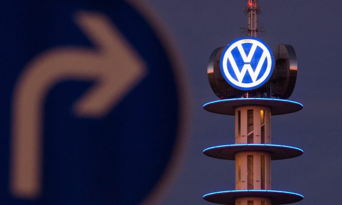 A street sign in front of an illuminated logo of German automaker Volkswagen in Hanover, Germany. (Julian Stratenschulte/AFP/Getty Images)