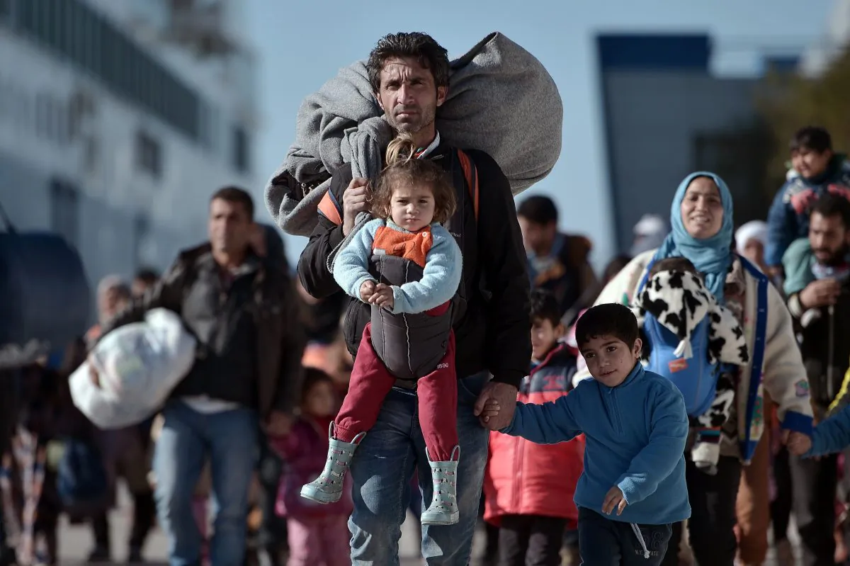 Thousands of migrants and refugees walk through the port of Piraeus after arriving from the Greek islands of Lesbos and Chios on Feb. 1, 2016. (Louisa Gouliamaki/AFP/Getty Images)