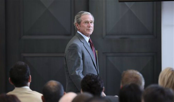Former President George W. Bush walks off the stage after giving a speech before a U.S. citizen swearing in ceremony at the The George W. Bush Presidential Center in Dallas on July 10, 2013. (AP Photo/LM Otero)