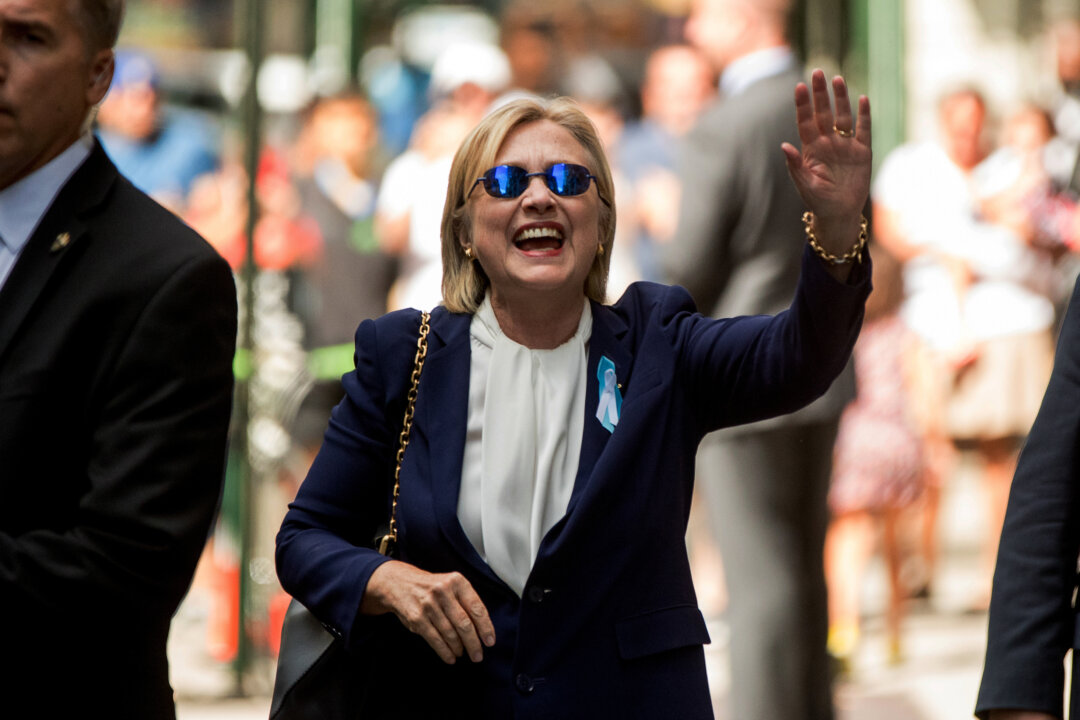 Democratic presidential candidate Hillary Clinton waves after leaving an apartment building Sunday, Sept. 11, 2016, in New York. Clinton's campaign said the Democratic presidential nominee left the 9/11 anniversary ceremony in New York early after feeling "overheated." (AP Photo/Andrew Harnik)