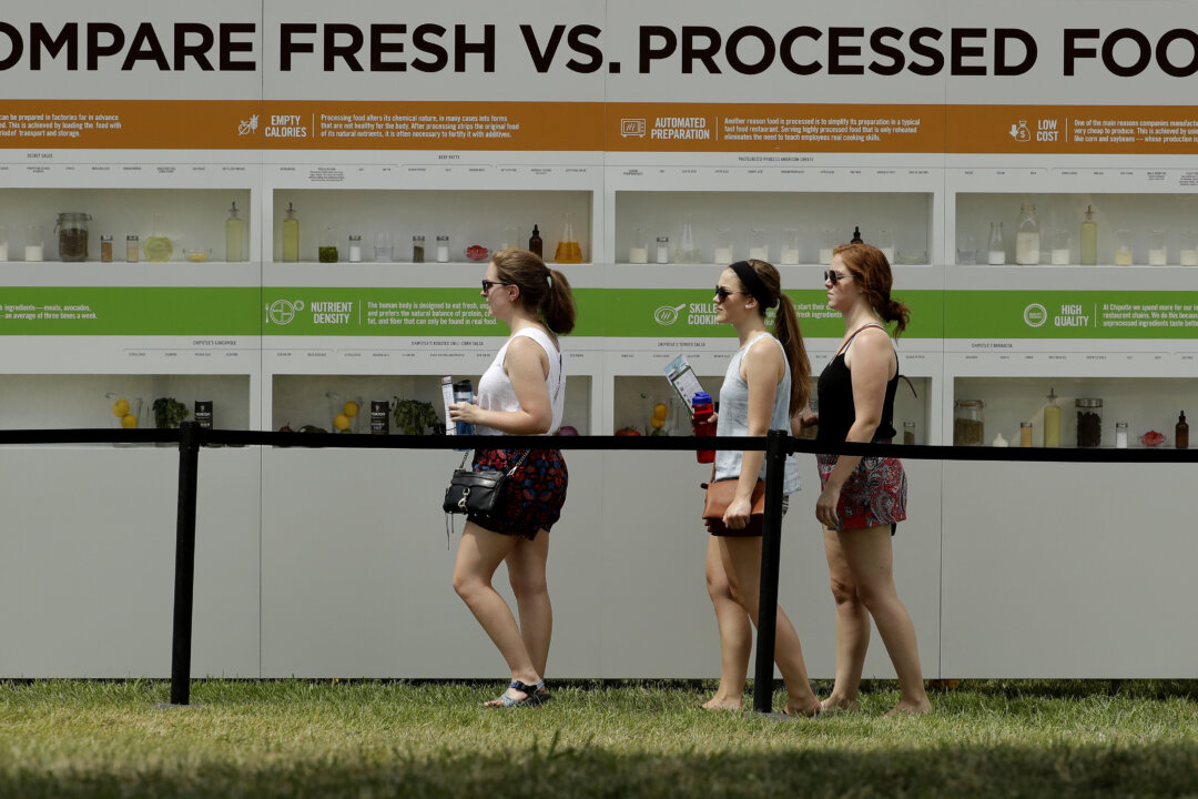 People are reflected in windows as they view a display contrasting processed and fresh food at Chipotle's Cultivate Festival in Kansas City, Mo., on July 23, 2016. Cultivate festivals encapsulate the food industry’s hottest marketing trend: crusading against Big Food. (Charlie Riedel/AP)