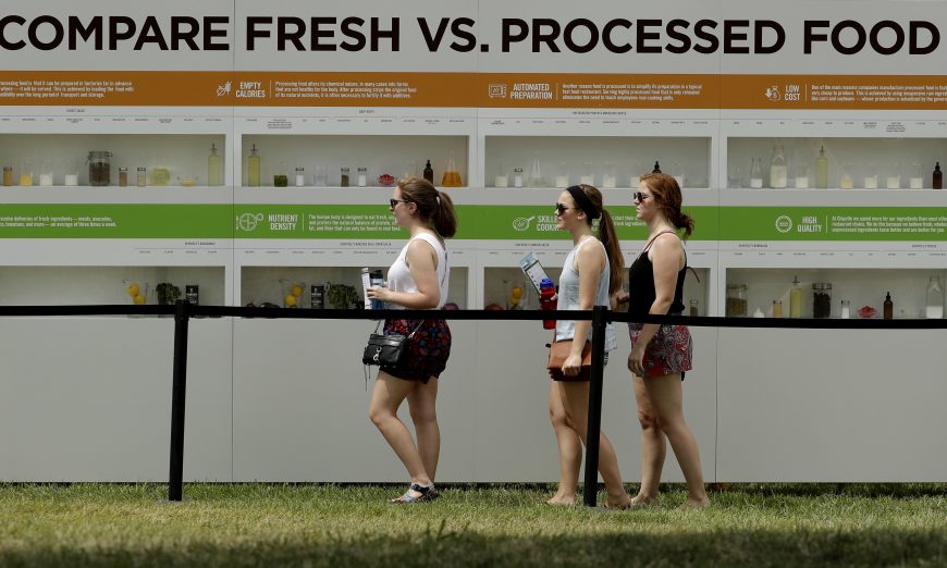 People are reflected in windows as they view a display contrasting processed and fresh food at Chipotle's Cultivate Festival in Kansas City, Mo., on July 23, 2016. Cultivate festivals encapsulate the food industry’s hottest marketing trend: crusading against Big Food. (Charlie Riedel/AP)