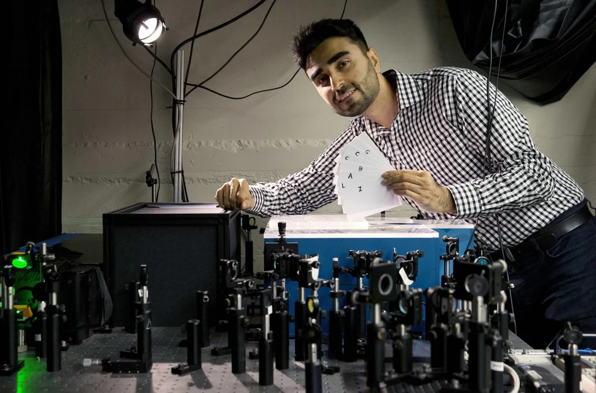 Barmak Heshmat poses with his prototype scanning device in a lab at the Massachusetts Institute of Technology in Cambridge, Mass. Researchers came up with a technology that can read the pages of a book without opening it, which could help museums analyze antique books and ancient texts. (Michael Dwyer/AP Photo)