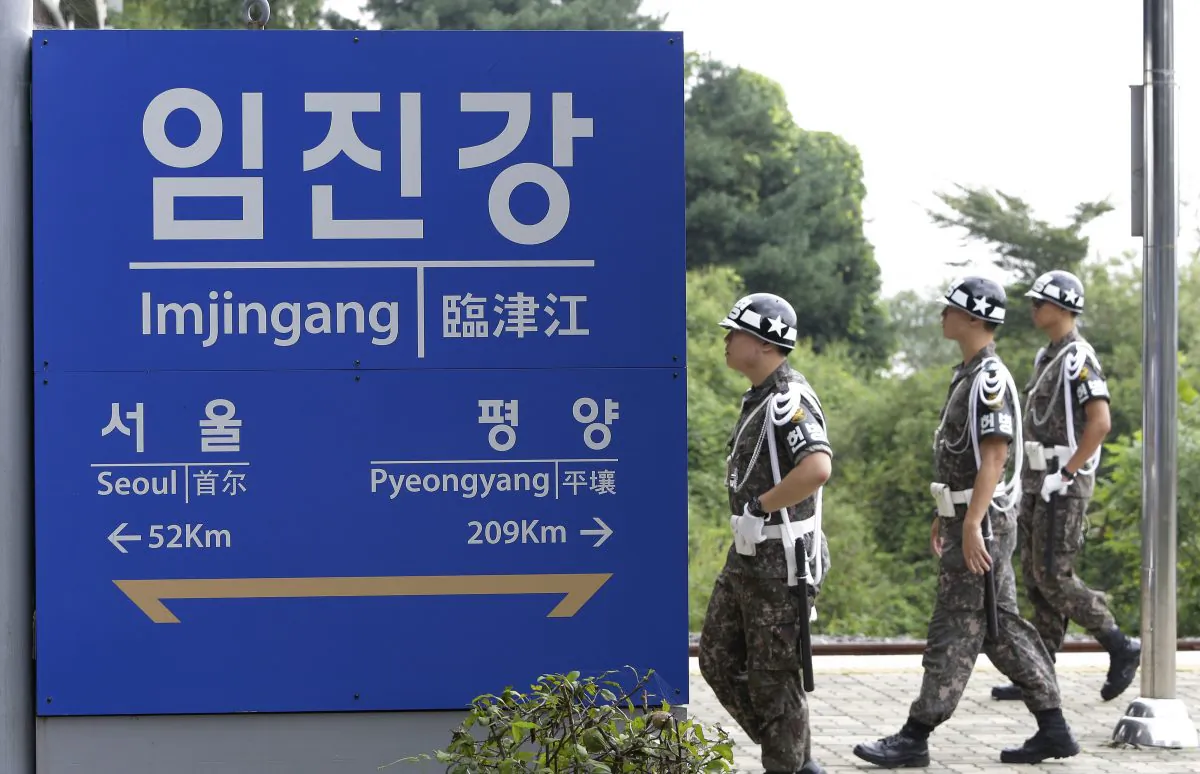 South Korean army soldiers walk by a signboard showing the distance to the North Korean capital Pyongyang and to South's capital Seoul from Imjingang Station near the border village of the Panmunjom in Paju on Sept. 11, 2016. (Ahn Young-joon/AP)
