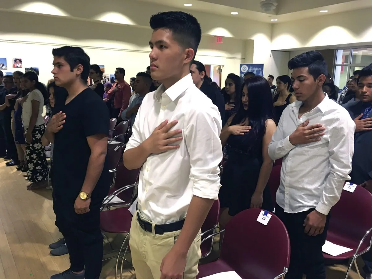 In this Aug. 19, 2016 file photo, 16-year-old Long Chi Vong (C) from Albuquerque and other immigrants stand for the U.S. Pledge of Allegiance before taking the Oath of Citizenship at a ceremony in Rio Rancho, N.M. (Russell Contreras/AP Photo)