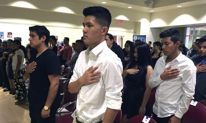 In this Aug. 19, 2016 file photo, 16-year-old Long Chi Vong (C) from Albuquerque and other immigrants stand for the U.S. Pledge of Allegiance before taking the Oath of Citizenship at a ceremony in Rio Rancho, N.M. (Russell Contreras/AP Photo)