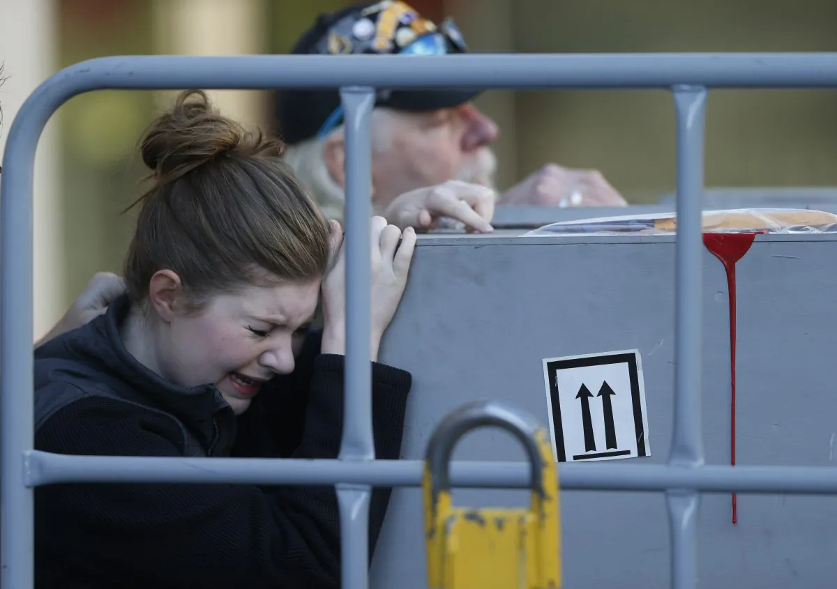 Katie Shirley of Arvada, Colo., joins her father, Russ, back, of Rapid City, S.D., in touching the casket bearing the body of her brother and his son, 24-year-old Levi Shirley, as the bodies of Shirley and Jordan MacTaggart were unloaded from an Amtrak train at Union Station early Friday, Sept. 16, 2016, in Denver. (AP Photo/David Zalubowski)