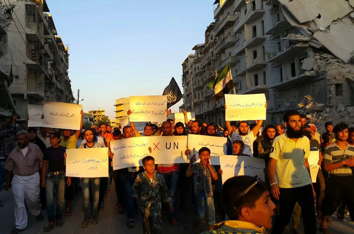 Activists in Syria’s besieged Aleppo protest against the United Nations for what they say is its failure to lift the siege off their rebel-held area, on Sept. 13, 2016. Dozens of protesters marched in al-Shaar neighborhood heading toward the Castello road, the area from which aid is expected to be delivered. “Hunger better than humiliation,” one banner read. “X the UN,” another read. (Modar Shekho via AP)