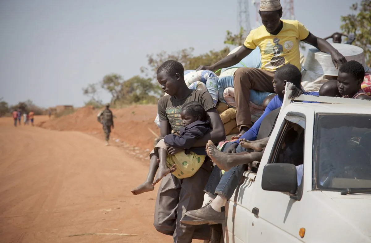 Refugees who fled the recent violence in South Sudan and crossed the border into Uganda arrive and await transportation from a transit center in the town of Koboko, Uganda, on Jan. 6 2014. (AP Photo/Rebecca Vassie)