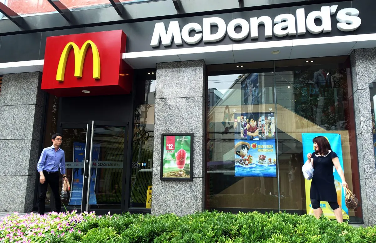 People walk by a McDonald's restaurant on July 28, 2014 in Shanghai. McDonald's is finalizing a sale of the rights to run its Chinese restaurants. (Johannes Eisele/AFP/Getty Images)