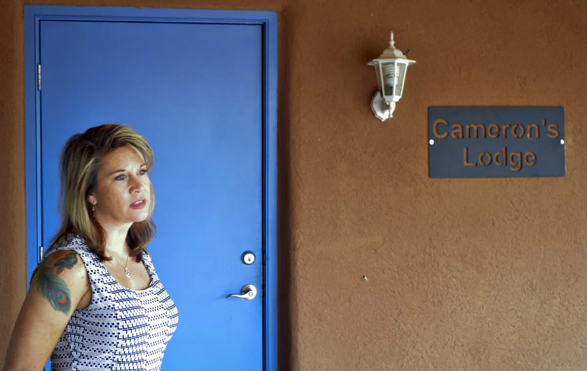 Jennifer Weiss-Burke, executive director of a youth recovery center, stands by one of the rooms at the recovery center named after her son, Cameron Weiss, in Albuquerque, N.M., on Aug. 9, 2016. He died of a heroin overdose in 2011. Weiss-Burke said her teenage son's descent into drug addiction started with an opioid prescription a doctor wrote for him for a wrestling injury. (AP Photo/Mary Hudetz)