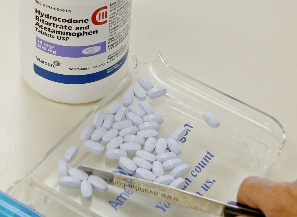A pharmacy technician poses for a picture with hydrocodone and acetaminophen tablets, also known as Vicodin, at the Oklahoma Hospital Discount Pharmacy in Edmond, Okla., Aug. 5, 2010. (Sue Ogrocki/AP Photo)