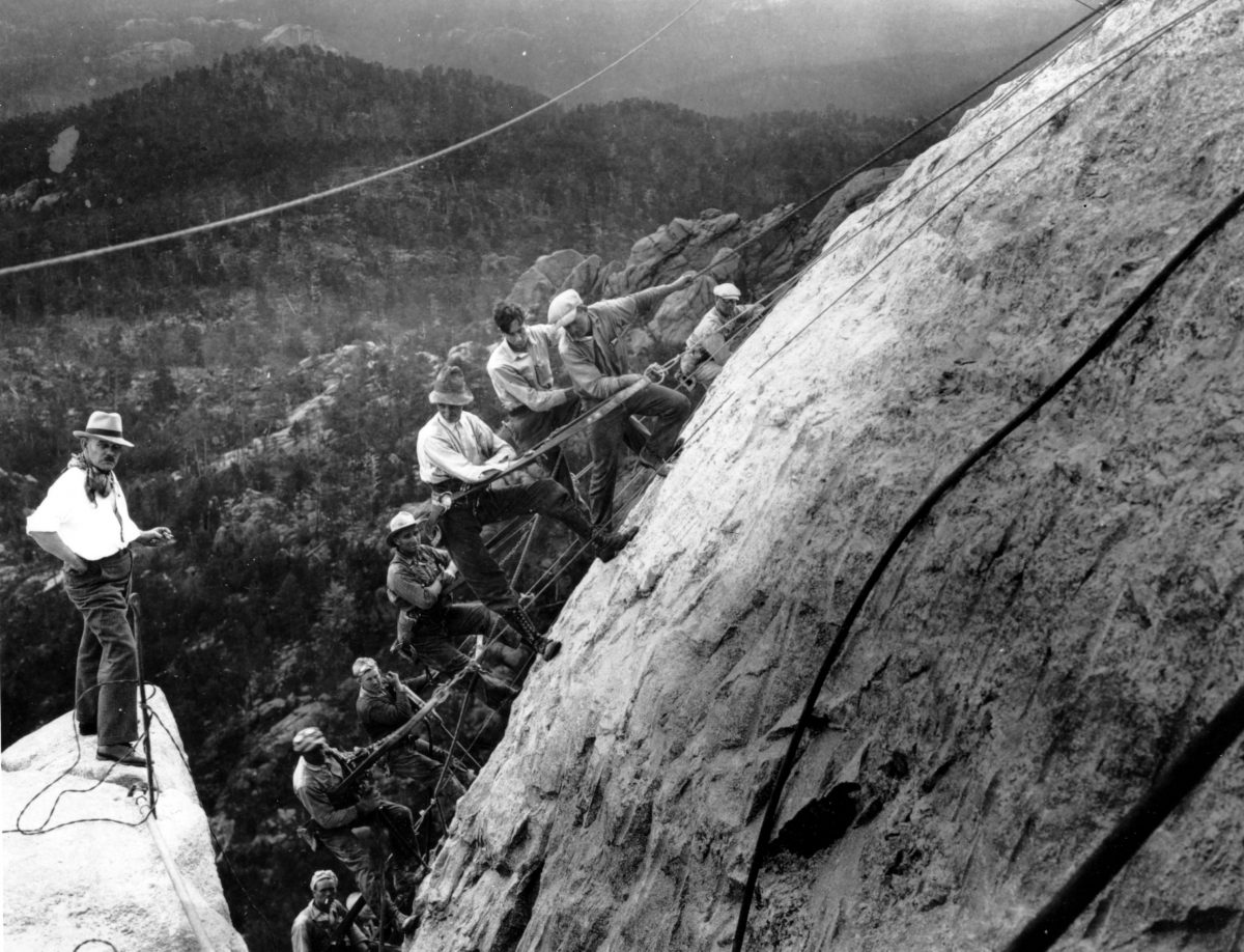 Sculptor Gutzon Borglum (L) directs drillers suspended by cables from the top of the mountain as they work on the head of President George Washington at the Mount Rushmore Memorial in the Black Hills area near Keystone, S.D., on July, 22, 1929. (AP Photo)
