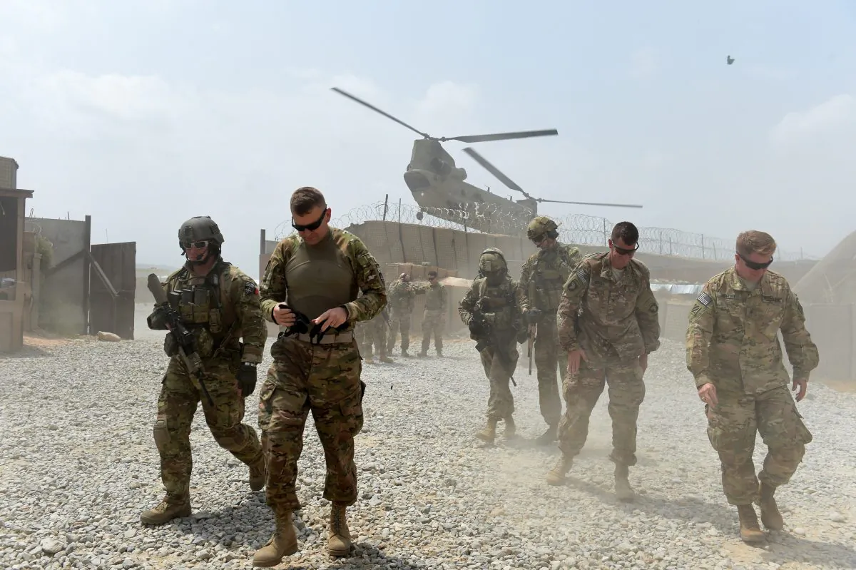 U.S. Army soldiers walk as a NATO helicopter flies overhead at coalition force Forward Operating Base (FOB) Connelly in the Khogyani District in eastern Afghanistan's Nangarhar Province on Aug. 13, 2015. (Wakil Kohsar/AFP/Getty Images)