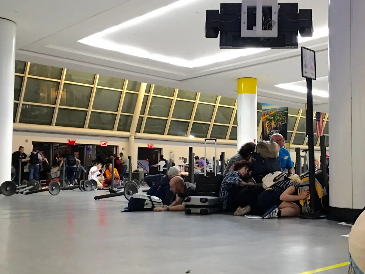 Passengers take cover while police looking for an active shooter at JFK International airport in New York on Aug. 14, 2016. (BRIGITTE DUSSEAU/AFP/Getty Images)