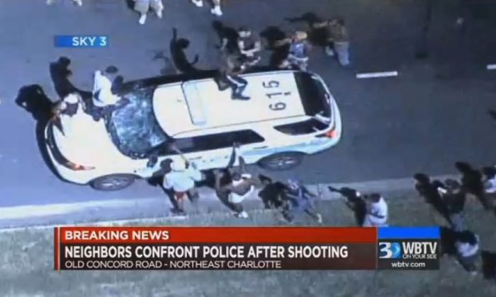 In this frame from video provided by WBTV, a police vehicle is damaged after protests broke out Tuesday, Sept. 20, 2016, in Charlotte, N.C., following a fatal shooting of a black man by police. (WBTV via AP)