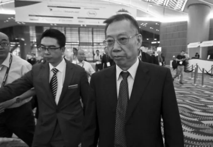 Huang Jiefu, the spokesperson on Chinese transplantation issues, dodges reporters at The Transplantation Society’s recent biennial conference in Hong Kong on Aug. 19. (Yu Kong/Epoch Times)