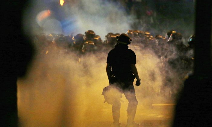Police fire teargas as protestors converge on downtown following Tuesday's police shooting of Keith Lamont Scott in Charlotte, N.C., Wednesday, Sept. 21, 2016. (AP Photo/Gerry Broome)