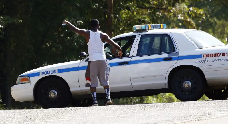 A resident gestures to an officer as a police presence remained in a south Jackson, Miss., neighborhood on Sept. 22, 2016. (AP Photo/Rogelio V. Solis)
