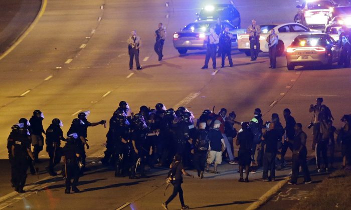 Police confront protesters blocking I-277 during a third night of unrest following Tuesday's police shooting of Keith Lamont Scott in Charlotte, N.C., Thursday, Sept. 22, 2016. (AP Photo/Gerry Broome)