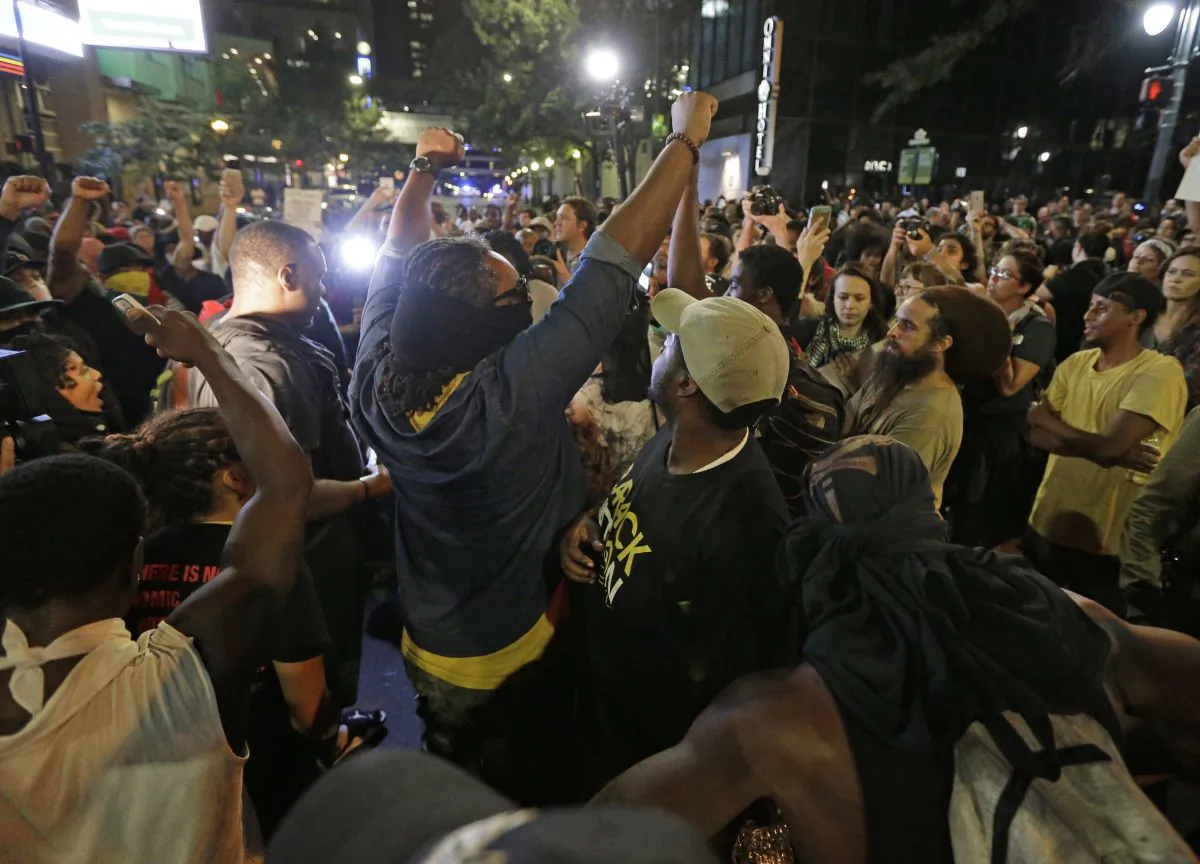 Protesters shout as they march downtown on the third night of protests in Charlotte, N.C. Thursday, Sept. 22, 2016, following Tuesday's fatal police shooting of Keith Lamont Scott in Charlotte, N.C. (AP Photo/Chuck Burton)