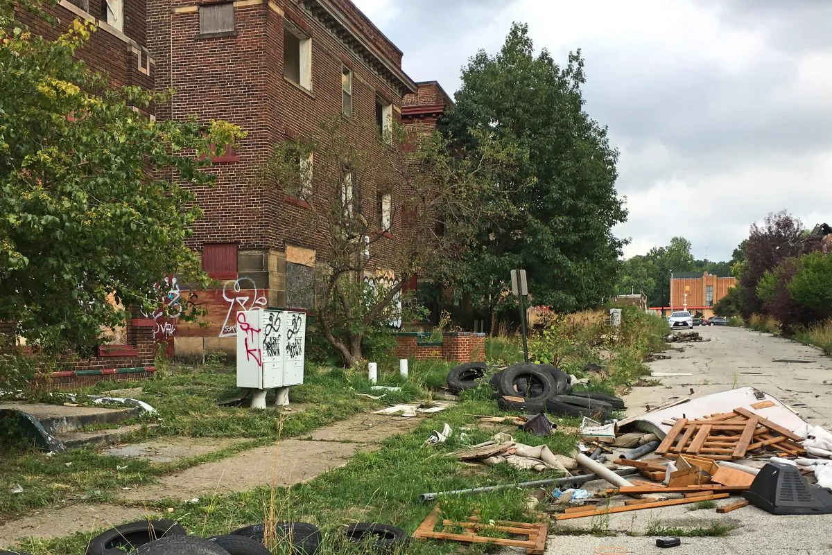 Discarded tires and other refuse pile up on cracked pavement and sidewalks alongside graffiti-scarred buildings with missing windows in East Cleveland, Ohio, on Aug. 31, 2016. Cleveland and East Cleveland, two of the country's poorest cities, are debating whether to merge, with both cities saying the state of Ohio needs to provide millions to begin fixing East Cleveland's infrastructure and finances. (AP Photo/Mark Gillispie)