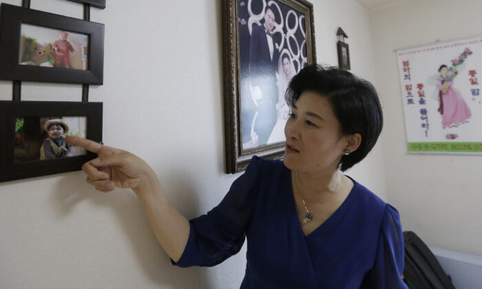North Korean defector Kim Jungah points to a photo of her son left behind in China, during an interview at her house in Gunpo, South Korea, on Sept. 4, 2016. (AP Photo/Ahn Young-joon)