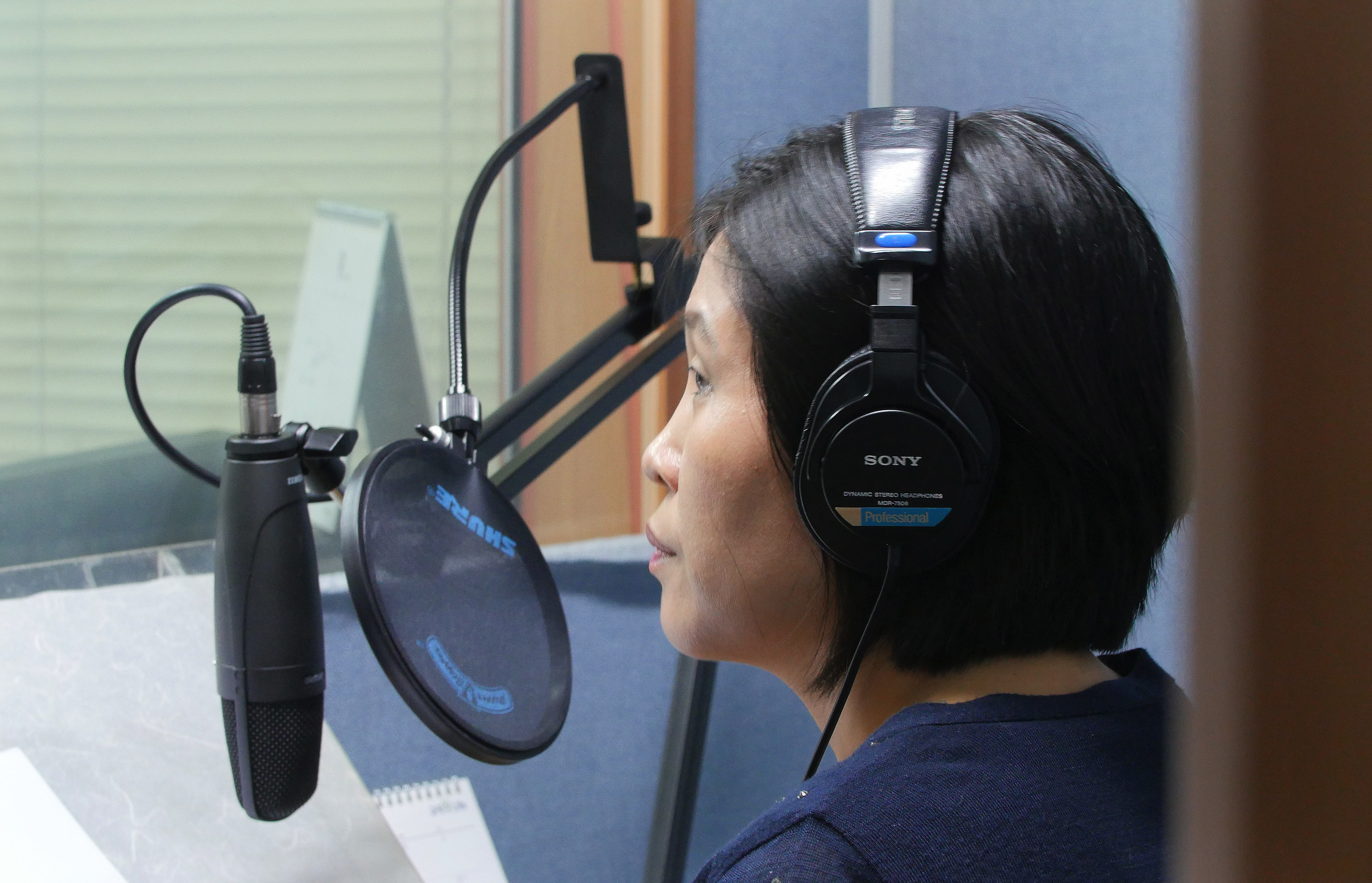 North Korean defector Park Kyung-hwa who works for a Seoul-based shortwave radio station targeting audience in North Korea, demonstrates how she records her broadcast at a church in Seoul, South Korea, on Aug. 25, 2016. Park, who fled the North in 2000 before being sold to a Chinese man, said she saw brokers grope other trafficked women many times. She said brokers kicked and beat her with wooden clubs for about 20 minutes when her first attempt to escape failed. (AP Photo/Jungho Choi)