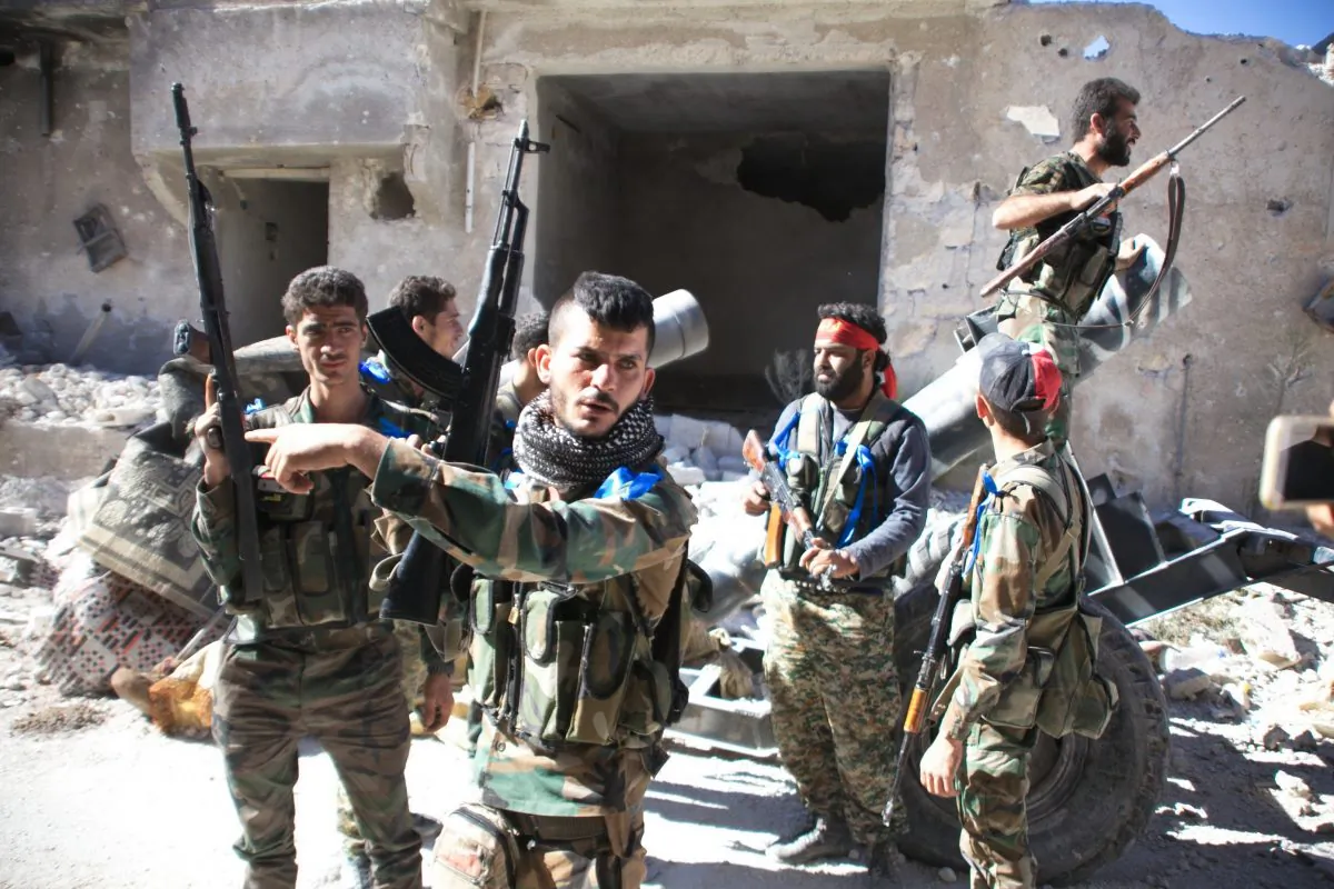 Syrian government forces gather in the largely deserted Palestinian refugee camp of Handarat, north of Aleppo, on Sept. 24, 2016, after they captured the area following multiple Russian airstrikes. Syrian regime forces had been fighting to take the camp for months because it is on high ground that overlooks the rebel-held east of the embattled city of Aleppo. (George Ourfalian/AFP/Getty Images)