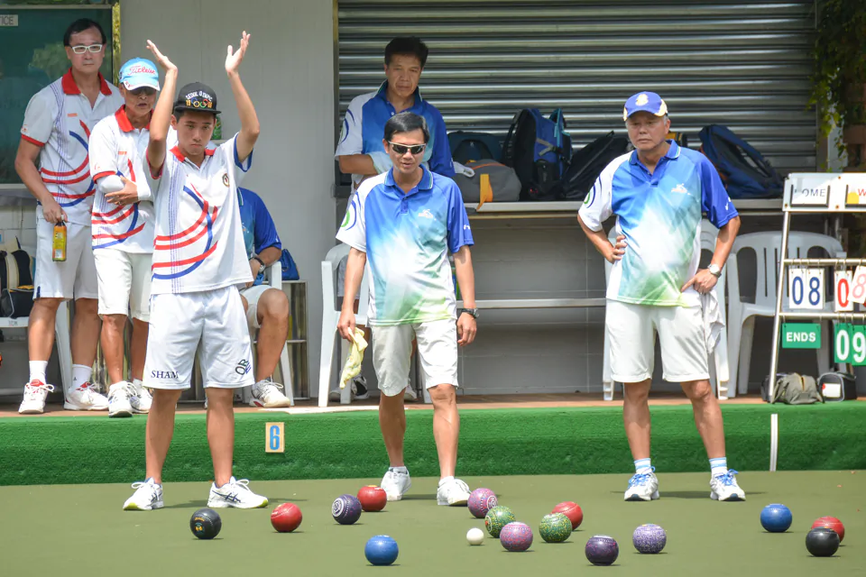 In the postponed game between the Police and Kowloon Bowling Green Club last Sunday, Sept 25, Martin Sham (hand raised) of KBGC applauds a good bowl from his skipper Anthony Yip (not in photo). The game finished at 14-14 but KBGC prevailed with a 3-5 victory. The defeat pushed the Police team into big trouble and they need to win their last two games to survive.
(Stephanie Worth)