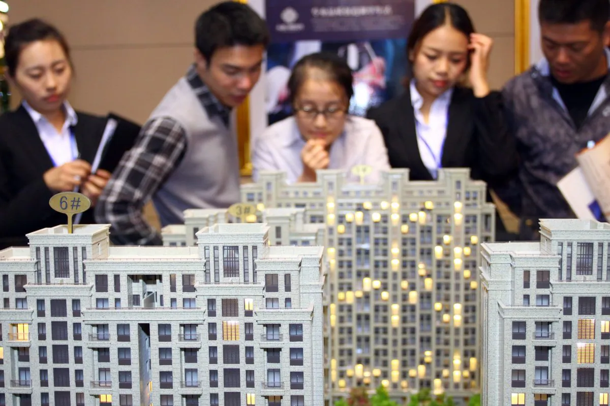 Customers and real estate agents look at several building models at a real estate exhibition in Jiashan, in China's Zhejiang Province, in this undated photo. (AFP/AFP/Getty Images)