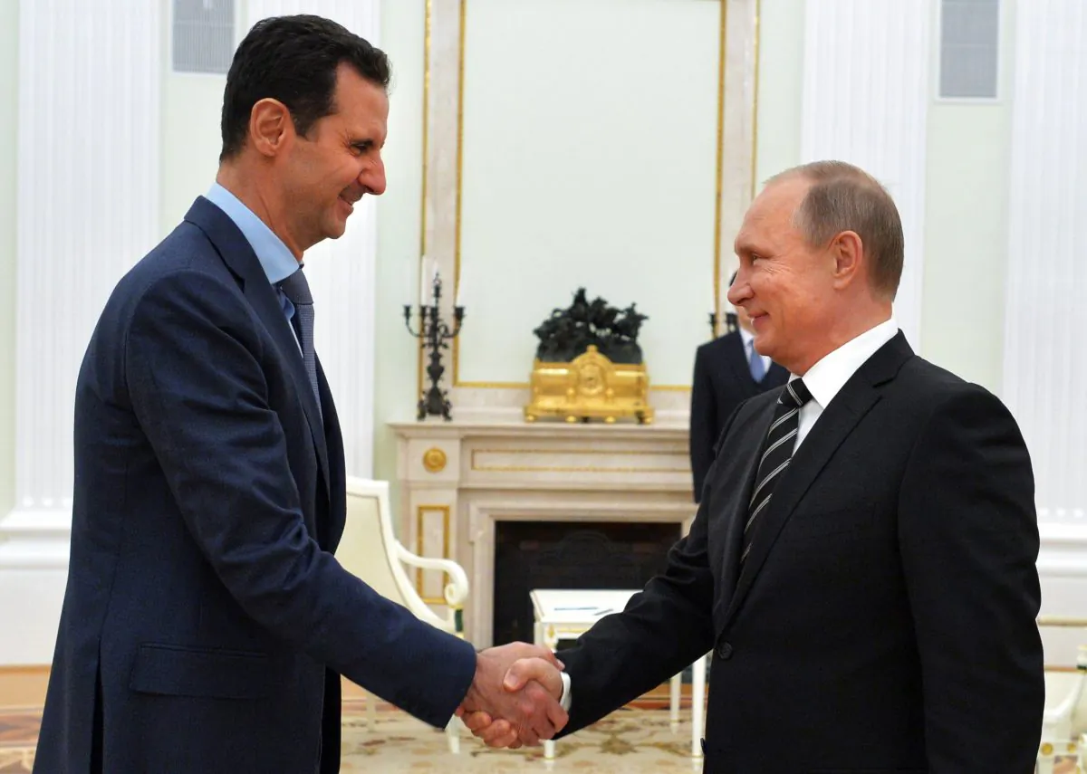 Russian President Vladimir Putin shakes hands with his Syrian counterpart Bashar al-Assad at the Kremlin in Moscow on Oct. 20, 2015. (ALEXEY DRUZHININ/AFP/Getty Images)