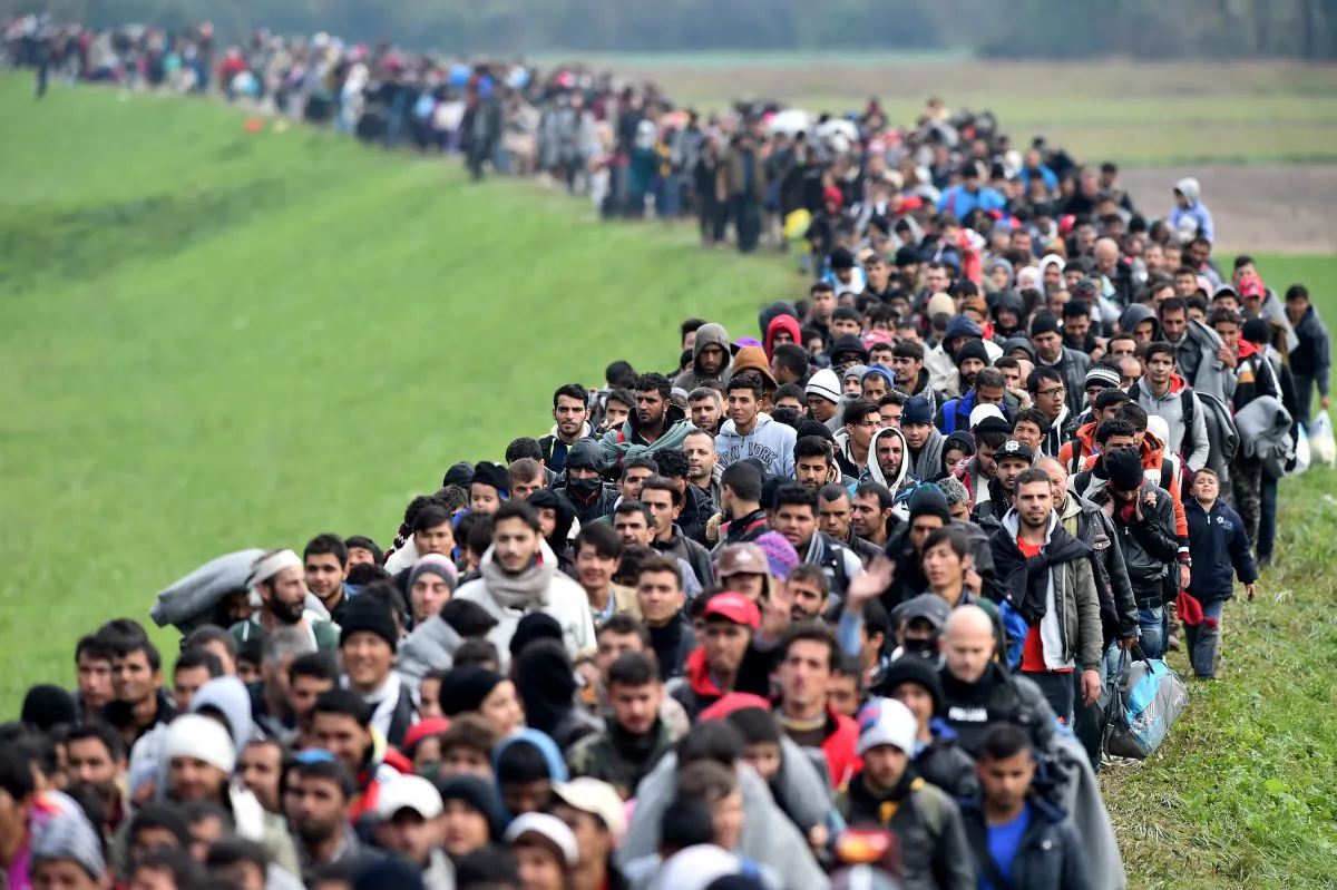 Migrants are escorted through fields by police as they are walked from the village of Rigonce to Brezice refugee camp in Rigonce, Slovenia, on Oct. 23, 2015. (Jeff J. Mitchell/Getty Images)