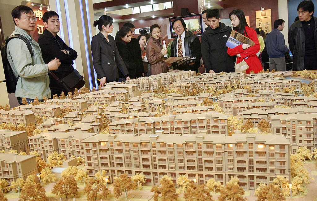A group of potential real estate buyers look at an estate plan by a local developer at a property exhibition in Shanghai on March 19, 2006. (Mark Ralston/AFP/Getty Images)