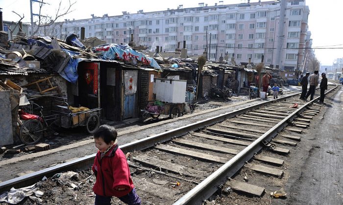 A child plays along a railway at a shanty town where residents will move into low-rent apartments provided by the government in Shenyang of Liaoning Province on March 11, 2009. (China Photos/Getty Images)