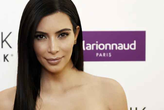 US reality TV star Kim Kardashian poses during a photocall to present her new cosmetic brand in Paris on April 15, 2015. The hotel concierge involved in Paris robbery writes letter to Kardashian. (LOIC VENANCE/AFP/Getty Images)