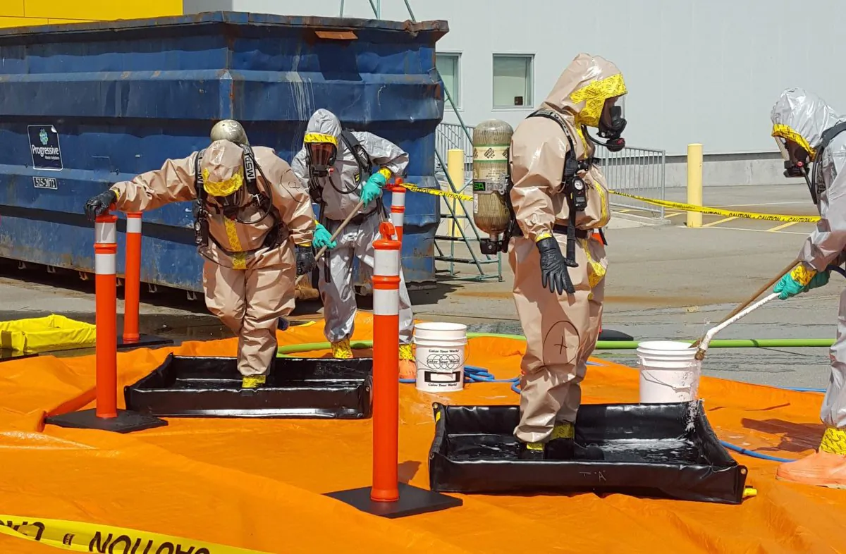 Members of the RCMP go through a decontamination procedure in Vancouver after intercepting a package containing approximately 1 kilogram (2.2 pounds) of the powerful opioid carfentanil imported from China on June 27, 2016. (Royal Canadian Mounted Police via AP)