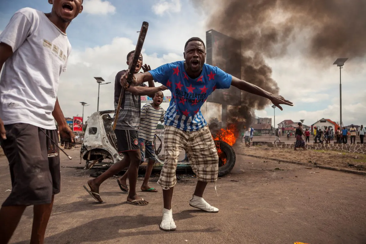 Demonstrators gather in front of a burning car during an opposition rally in Kinshasa on Sept. 19, 2016. Police fired tear gas at scores of opposition supporters rallying in Kinshasa to demand that DR Congo's long-serving President Joseph Kabila step down this yea (AFP / EDUARDO SOTERAS/Getty Images) 