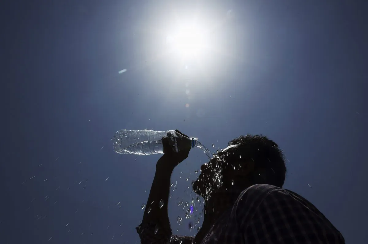 A man pours water on his face during a hot summer day. (Mahesh Kumar A/AP Photo)