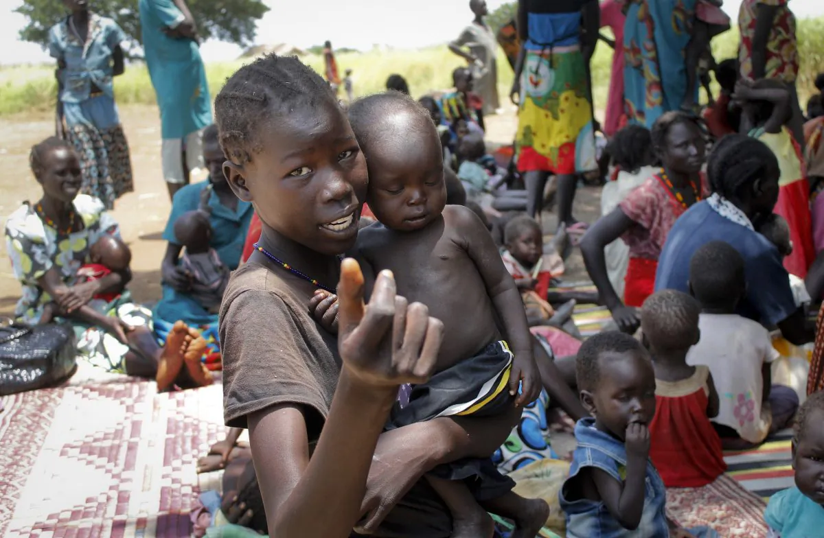 A young girl holds a child at a UNICEF clinic for severely malnourished children in Aweil, South Sudan, on Sept. 16, 2016. (Justin Lynch/AP Photo)