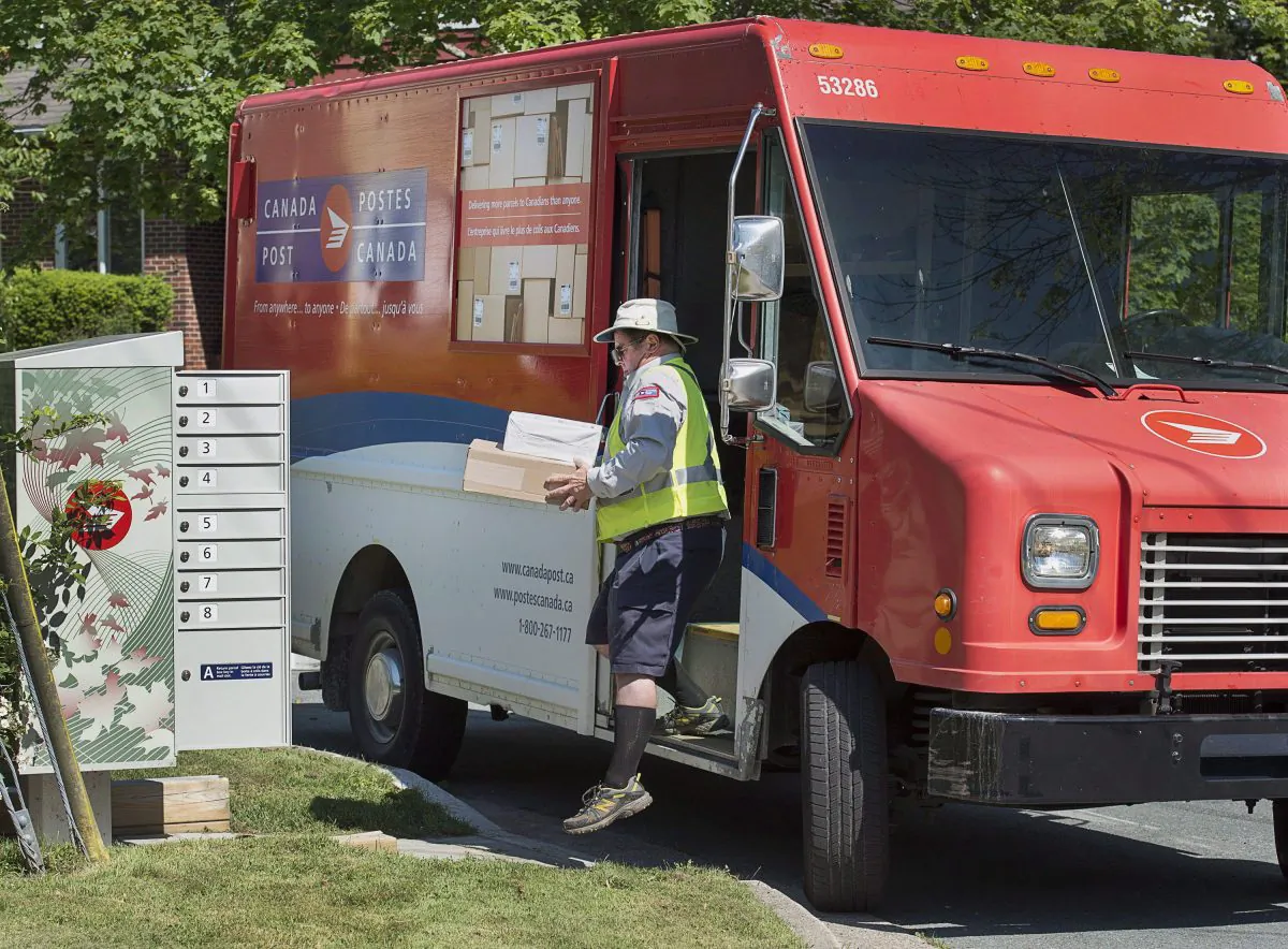 A Canada Post employee delivers mail to a community mailbox in Dartmouth, N.S., in a file photo. (Andrew Vaughan/The Canadian Press)